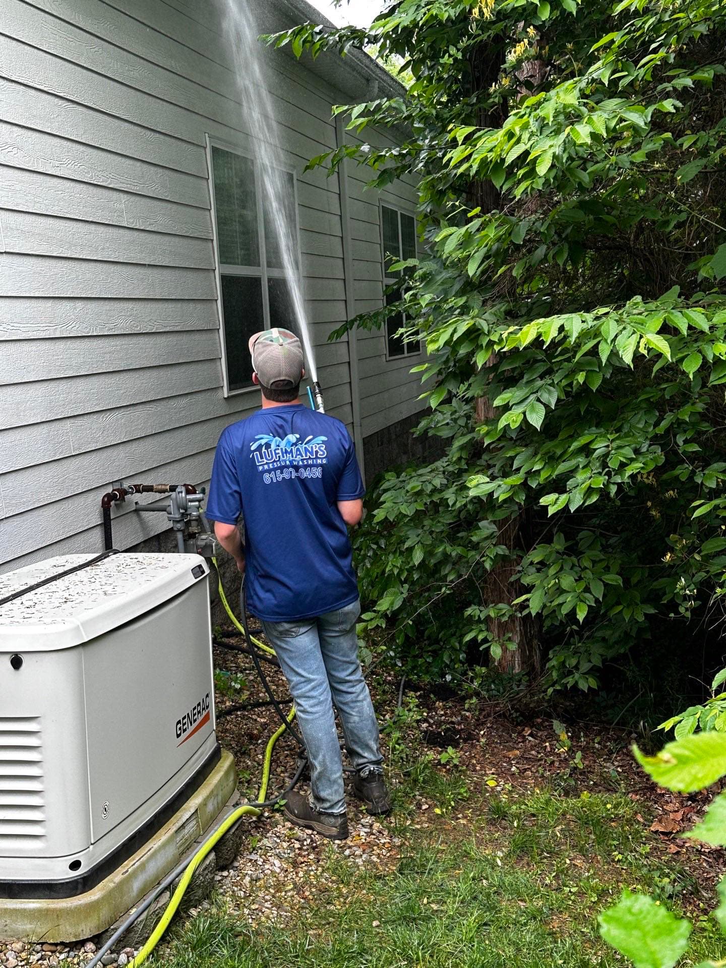 Technician performing soft wash house washing in Brentwood, TN
